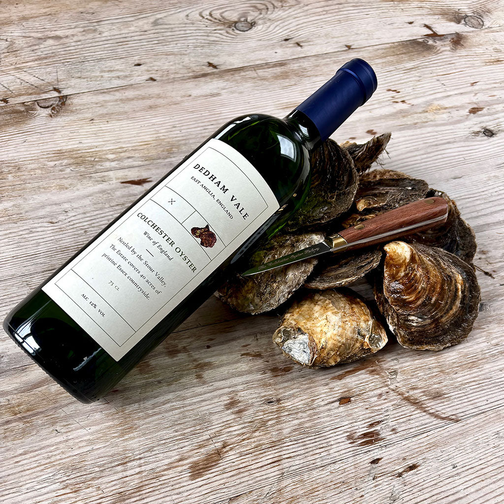 Bottle of Dedham Vale Colchester Oyster wine with oysters on a wooden surface