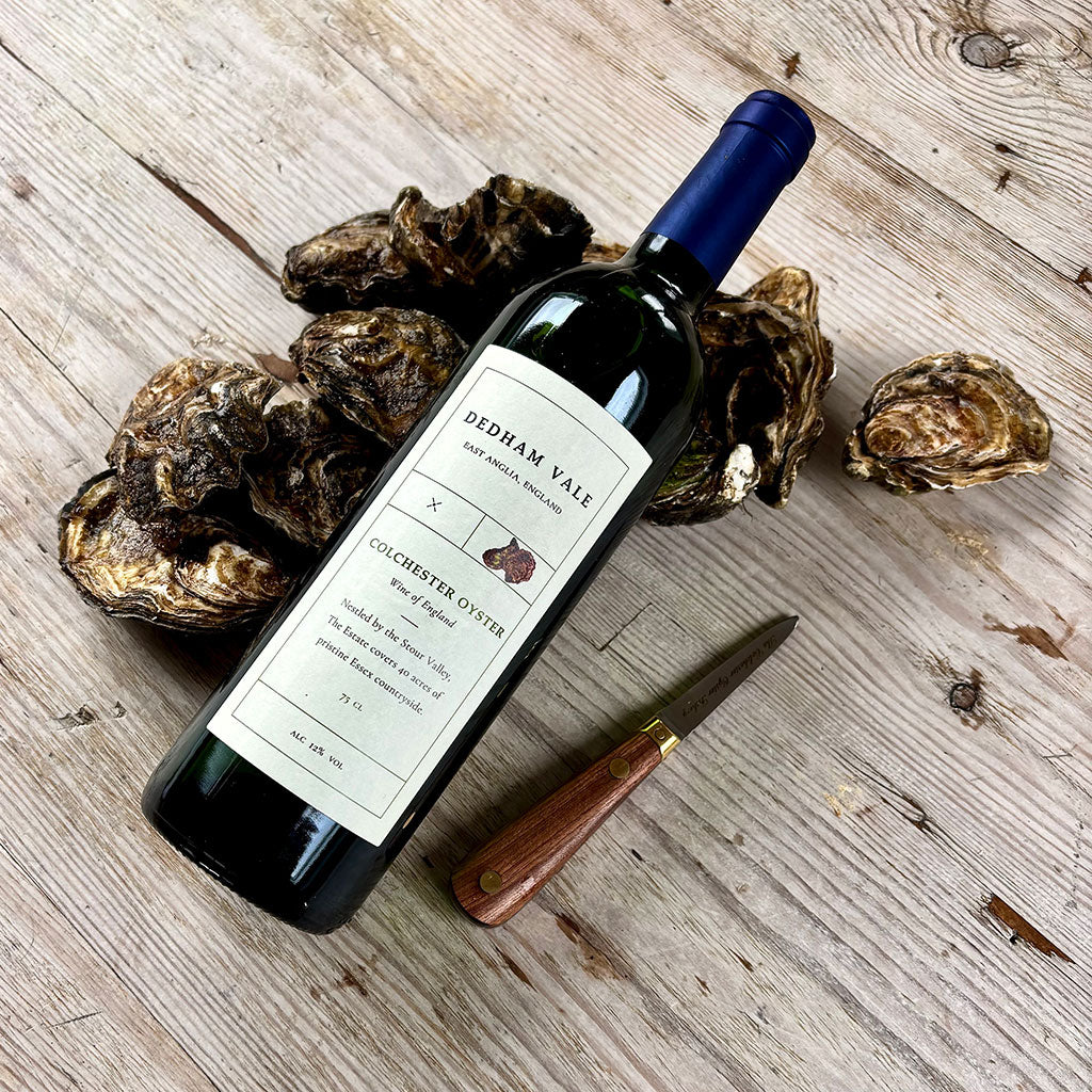Bottle of Redham Vale wine with oysters on a wooden surface